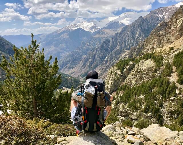 Person Wearing Hiking Headphones Sitting On Mountain