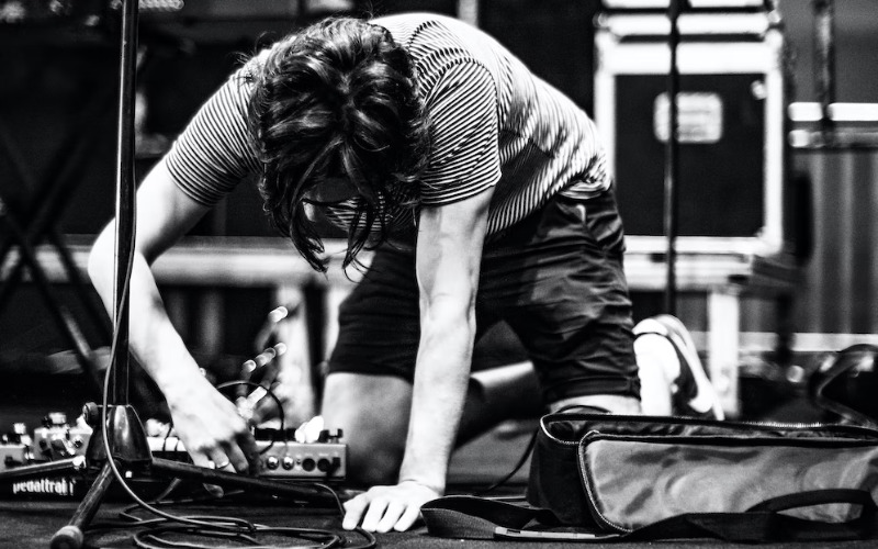 Worker setting up audio cables at music concert