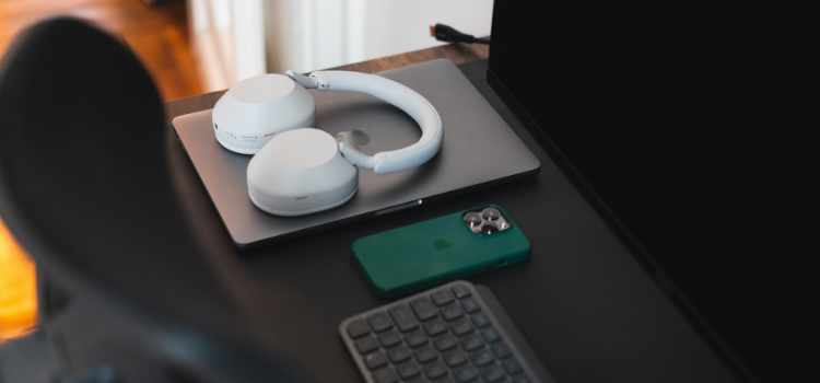 Sony XM5 headphones and iPhone on desk